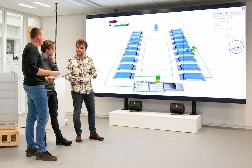 De studenten Pim Veroude (Fontys ICT, rechts) en Fabian Claassen (TU/e, midden) met hun opdrachtgever Paul Driessen op de werkvloer bij KMWE